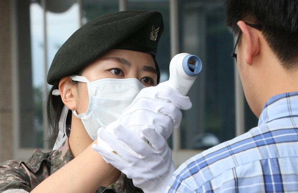 A Korean soldier checks a person for MERS symptoms (Yonhap)