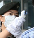 A Korean soldier checks a person for MERS symptoms (Yonhap)