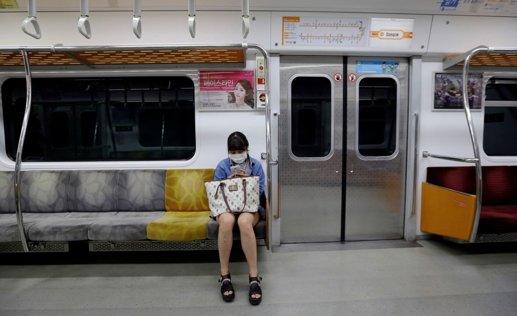 A passenger wears a mask as a precaution against the MERS, Middle East Respiratory Syndrome, virus on a subway train in Seoul, South Korea, Sunday, June 7, 2015. A fifth person in South Korea has died of the MERS virus, as the government announced Sunday it was strengthening measures to stem the spread of the disease and public fear.(AP Photo/Ahn Young-joon)