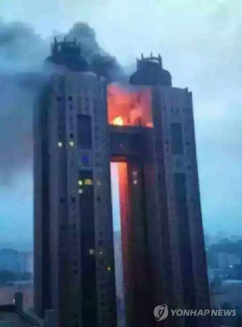 In this photo, exclusively obtained and released on June 12, 2015 by local radio station BBS, black smoke and flames billow from a bridge between the 43rd floors of Koryo Hotel in the North Korean capital of Pyongyang on the previous day. The fire had broken out at the hotel frequented by foreigners, without any information being provided on casualties or property damage, reports said on June 12, 2015. The fire appears to have been extinguished, according to The Associated Press. (Yonhap)