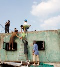 Campaigners of Seoul's "Cool Roof Project" paint a rooftop of a building in Dongdaemun-gu white, Sunday. (Yonhap)