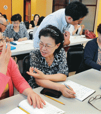 Charles H. Kim Elementary School teacher Michael Park teaches English conversation to a YMCA class. (Park Sang-hyuk/Korea Times)