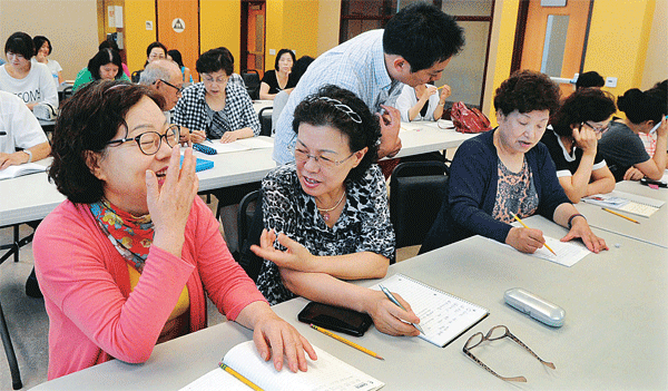 Charles H. Kim Elementary School teacher Michael Park teaches English conversation to a YMCA class. (Park Sang-hyuk/Korea Times)