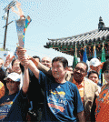 The Special Olympics torch run passed through Koreatown in Los Angeles Thursday. Retired policeman Park Noh-hyun, center, and Los Angeles City Council President Herb Wesson, third from right, were among those who came out for a cultural celebration in front of Da Wool Jung. (Choi Kyung-geun/Korea Times)