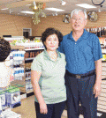 Teresa Kim, left, with husband Gyun-tae Kim stand inside their newly reopened beauty supply store in Baltimore.