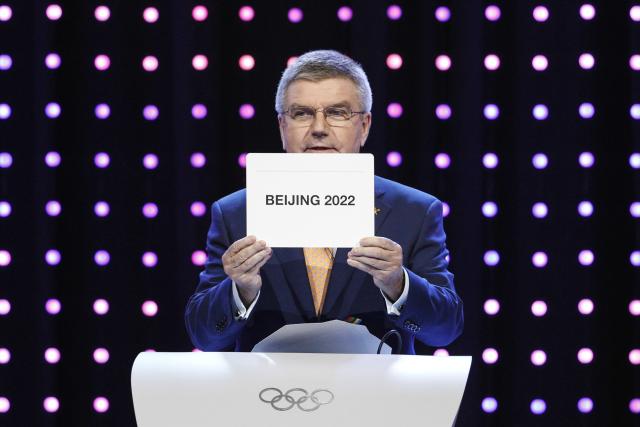President of the International Olympic Committee (IOC) Thomas Bach opens the envelope announcing that Beijing has won the bid to host the 2022 Winter Olympic Games at the 128th International Olympic Committee session in Kuala Lumpur, Malaysia, Friday, July 31, 2015. Almaty and Beijing competed for the right to host the 2022 Winter Olympic Games. (AP Photo/Joshua Paul)