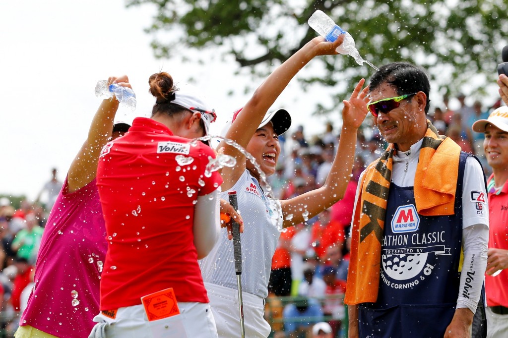 Chella Choi, front left, of South Korea, and her father and caddie Ji Yeon Choi, right, are doused by Mi Hyang Lee, also of South Korea, after winning the Marathon Classic golf tournament on the first playoff hole at Highland Meadows Golf Club in Sylvania, Ohio, Sunday, July 19, 2015. (AP Photo/Rick Osentoski)