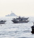 Guarded by South Korean naval ships, fishing boats operate. (Yonhap)