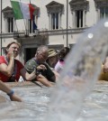 People cool off in a public fountain past Rome's Palazzo Chigi government office, Monday, July 20, 2015. Temperatures in Rome this week could hit 38-39C (100-102F): sizzling heat and oppressive humidity have gripped Italy this month, with some nights in Rome seeing "low" temperatures hovering near 30C (86F). (AP Photo/Gregorio Borgia)