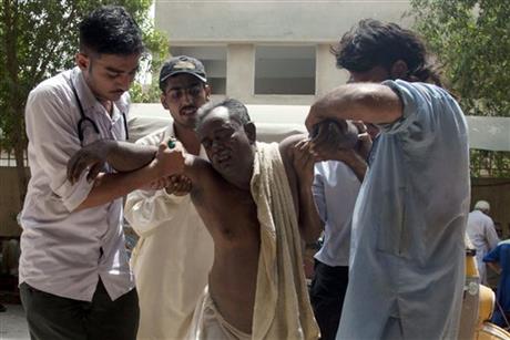 FILE - In this June 23, 2015, file photo, people rush a patient to a hospital suffering from heatstroke in Karachi, Pakistan. June was warm nearly all over, with exceptional heat in Spain, Austria, parts of Asia, Australia and South America. Pakistan reported a June heat wave that killed more than 1,200 people, which according to an international database would be the 8th deadliest in the world since 1900. (AP Photo/Shakil Adil, File)