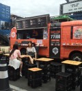 Kimchi Bus customers eat its kimchi-infused Mexican dishes in front of the truck located insdie the Common Ground shopping complex in eastern Seoul. (Korea Times/Kim Bo-eun)