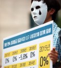 A protester rallies in front of the Korea Employers Federation building in Seoul on June 22, 2015, demanding the federation withdraw its decision to freeze the minimum wage for next year. The minimum wage for this year was set at 5,580 won per hour, a 7.1 percent rise from 2014. (Yonhap)