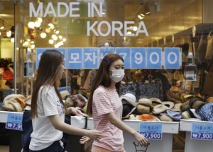 A woman wearing a mask as a precaution against Middle East Respiratory Syndrome (MERS) walks in a shopping district in Seoul, South Korea. (AP Photo/Ahn Young-joon)