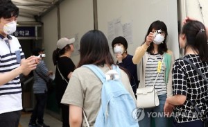 Public servant applicants of the Busan municipal government are checked for fever, a major symptom of Middle East Respiratory Syndrome, before entering the test area at a high school in Haeundae in the southeastern port city of Busan on June 27, 2015, as the country struggles to eliminate the potentially deadly disease. (Yonhap)