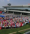 People gather during an opening ceremony of the new international airport terminal building at Pyongyang airport, Wednesday, July 1, 2015, in Pyongyang, North Korea. The unveiling Wednesday underscores an effort to attract more tourists and to spruce up the country ahead of the celebration of a major anniversary of the founding of its ruling Worker's Party in October this year. (AP Photo/Kim Kwang Hyon)