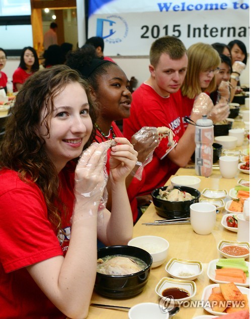 International students enjoy "samgyetang," chicken and ginseng with sticky rice soup, at Hansung University in Seoul on July 7, 2015, six days ahead of this year's "chobok," the first 10-day hot period during the dog days of summer. Koreans traditionally eat samgyetang to replenish their stamina on hot days.  (Yonhap) 