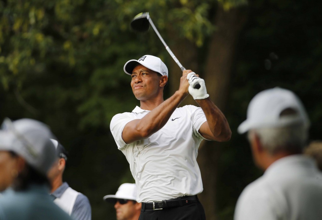 Tiger Woods watches his tee shot on the 18th hole during the first round of the Quicken Loans National golf tournament at the Robert Trent Jones Golf Club in Gainesville, Va., Thursday, July 30, 2015. (AP Photo/Steve Helber)