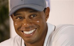 Tiger Woods smiles as he answers a question during a news conference prior to the start of the Quicken Loans National golf tournament at the Robert Trent Jones Golf Club in Gainesville, Va., Tuesday, July 28, 2015. (AP Photo/Steve Helber)