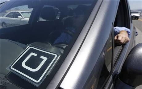 Uber driver Karim Amrani sits in his car parked near the San Francisco International Airport parking area in San Francisco, Wednesday, July 15, 2015. In the three months ended in June, Uber overtook taxis as the most expensed form of ground transportation, according to expense management system provider Certify. (AP Photo/Jeff Chiu)