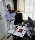 In this June 24, 2015 photo, South Korean violinist Won Hyung Joon performs during an interview at his office in Seoul, South Korea. Violinist Won wants to help the bitterly divided Korean Peninsula by bringing North and South Korean musicians together next month to perform on each side of the world’s most heavily armed border. Standing in the way is the rivals’ long, frustrating inability to forget their painful shared history. (AP Photo/Ahn Young-joon)