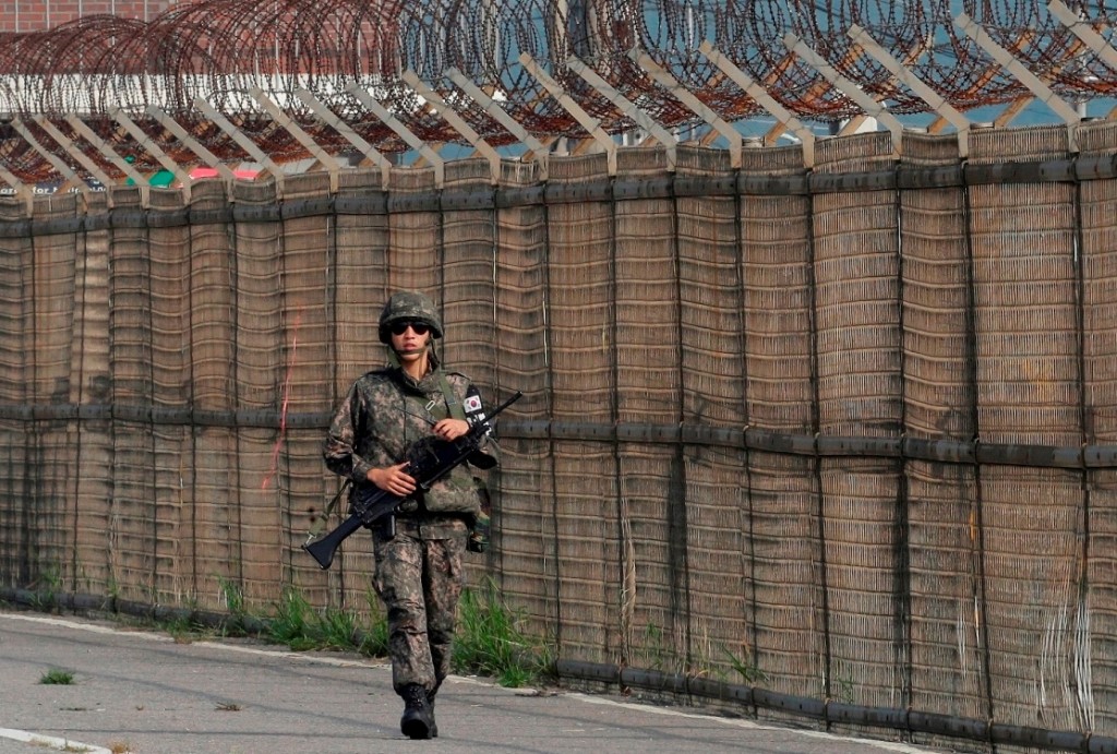A South Korean army soldier walks along the military wire fences on Unification Bridge, which leads to the demilitarized zone, near the border village of Panmunjom in Paju, South Korea, Saturday, Aug. 22, 2015. North Korean leader Kim Jong Un on Friday declared his front-line troops in a "quasi-state of war" and ordered them to prepare for battle a day after the most serious confrontation between the rivals in years. (AP Photo/Ahn Young-joon)