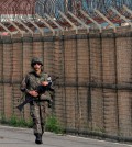A South Korean army soldier walks along the military wire fences on Unification Bridge, which leads to the demilitarized zone, near the border village of Panmunjom in Paju, South Korea, Saturday, Aug. 22, 2015. North Korean leader Kim Jong Un on Friday declared his front-line troops in a "quasi-state of war" and ordered them to prepare for battle a day after the most serious confrontation between the rivals in years. (AP Photo/Ahn Young-joon)