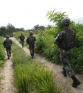 In this Aug. 9, 2015, photo provided by the Defense Ministry, South Korean army soldiers patrol near the scene of a blast inside the demilitarized zone in Paju, South Korea. Vowing to hit back, South Korea said Monday, Aug. 10, 2015, that North Korean soldiers laid the three mines that exploded last week at the border and maimed two South Korean soldiers. (The Defense Ministry via AP)