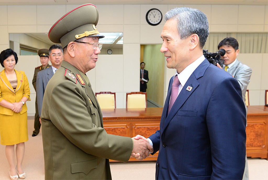 In this photo provided by the South Korean Unification Ministry, South Korean presidential security adviser Kim Kwan-jin, right, shakes hands with Hwang Pyong So, North Korea's top political officer for the Korean People's Army, after their meeting at the border village of Panmunjom in Paju, South Korea, Tuesday, Aug. 25, 2015. South Korea has agreed to halt propaganda broadcasts at noon Tuesday after North Korea expressed regret over a recent land mine blast that maimed two South Korean troops, both Koreas announced after three days of intense talks aimed at defusing soaring tension between the rivals.(The South Korean Unification Ministry via AP)