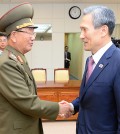 In this photo provided by the South Korean Unification Ministry, South Korean presidential security adviser Kim Kwan-jin, right, shakes hands with Hwang Pyong So, North Korea's top political officer for the Korean People's Army, after their meeting at the border village of Panmunjom in Paju, South Korea, Tuesday, Aug. 25, 2015. South Korea has agreed to halt propaganda broadcasts at noon Tuesday after North Korea expressed regret over a recent land mine blast that maimed two South Korean troops, both Koreas announced after three days of intense talks aimed at defusing soaring tension between the rivals.(The South Korean Unification Ministry via AP)