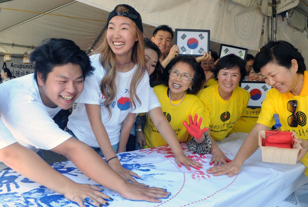 Festival goers at Seoul International Park made a Korean flag from handprints Saturday. (Park Sang-hyuk/Korea Times)