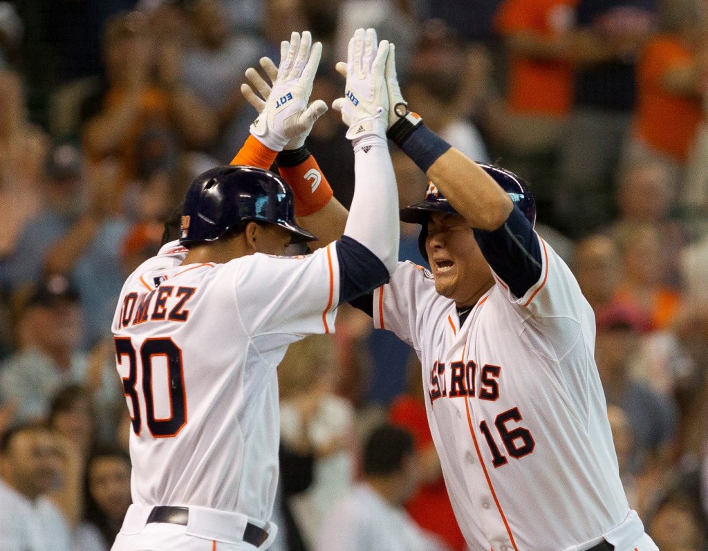 Houston Astros' Hank Conger, right, celebrates with Carlos Gomez after hitting a grand slam in the fourth inning of an MLB baseball game Saturday, Aug. 1, 2015. (Jason Fochtman/Conroe Courier via AP)