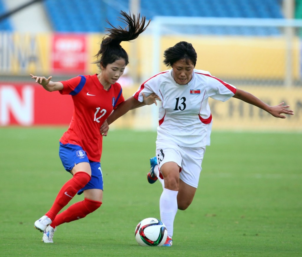 South Korea's Lee Min-ah, left, and North Korea's Wi Jung-shim fight for the ball. (Yonhap)