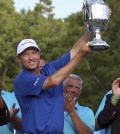 Davis Love III raises the trophy after winning the Wyndham Championship golf tournament at Sedgefield Country Club in Greensboro, N.C., Sunday, Aug. 23, 2015. (AP Photo/Rob Brown)