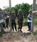 In this Aug. 9, 2015, photo provided by the Defense Ministry, an unidentified South Korean army official, second from right, gives a briefing to the media at the scene of a blast inside the demilitarized zone in Paju, South Korea. Vowing to hit back, South Korea said Monday, Aug. 10, 2015, that North Korean soldiers laid the three mines that exploded last week at the border and maimed two South Korean soldiers. (The Defense Ministry via AP)