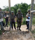 In this Aug. 9, 2015, photo provided by the Defense Ministry, an unidentified South Korean army official, second from right, gives a briefing to the media at the scene of a blast inside the demilitarized zone in Paju, South Korea. Vowing to hit back, South Korea said Monday, Aug. 10, 2015, that North Korean soldiers laid the three mines that exploded last week at the border and maimed two South Korean soldiers. (The Defense Ministry via AP)