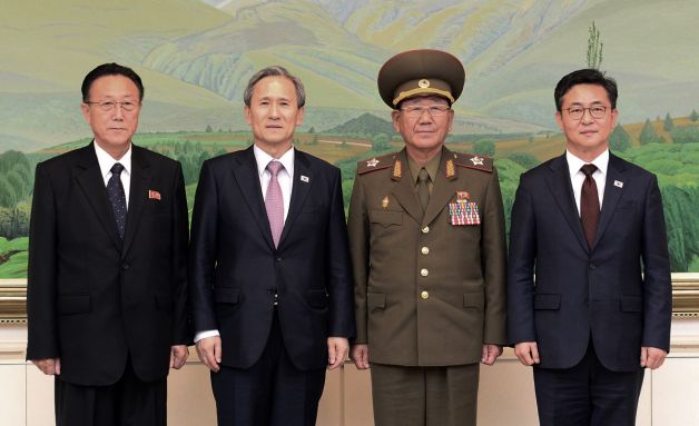 In this photo provided by the South Korean Unification Ministry, South Korean Unification Minister Hong Yong-pyo, right, and presidential security adviser Kim Kwan-jin, second from left, pose with Kim Yang-gon, right, a senior North Korean official responsible for South Korean affairs, and Hwang Pyong-so, North Korea' top political officer for the Korean People's Army, after their meeting at the border village of Panmunjom in Paju, South Korea, Tuesday, Aug. 25, 2015.(The South Korean Unification Ministry via AP)