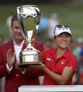 Lydia Ko, of New Zealand, holds up her trophy after defeating Stacy Lewis, of the United States, in a playoff at the Canadian Pacific Women's Open golf tournament at Vancouver Golf Club in Coquitlam, British Columbia, on Sunday, Aug. 23, 2015. (Jonathan Hayward/The Canadian Press via AP)