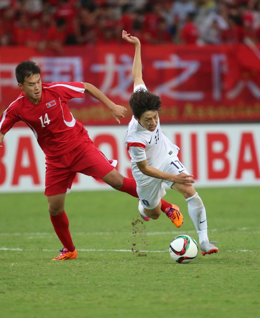 South Korea's Lee Jae-sung, right, gets tripped up by North Korea's Suh Kyung-jin. (Yonhap)