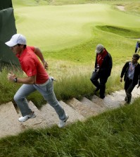 Rory McIlroy, of Northern Ireland, jogs off the18th green after a practice round for the PGA Championship golf tournament at Whistling Straits Golf Course on Monday, Aug. 10, 2015 in Haven, Wis. (AP Photo/Chris Carlson)
