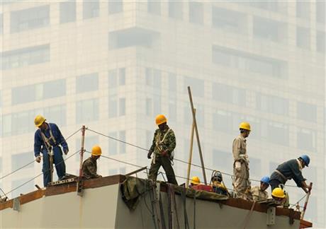 FILE - In this June 16, 2015, file photo, laborers work on a smoggy day in Beijing. A new study shows that air pollution is killing about 4,000 people in China a day, accounting for 1 in 6 premature deaths in the world’s most populous country. (AP Photo/Mark Schiefelbein, File)