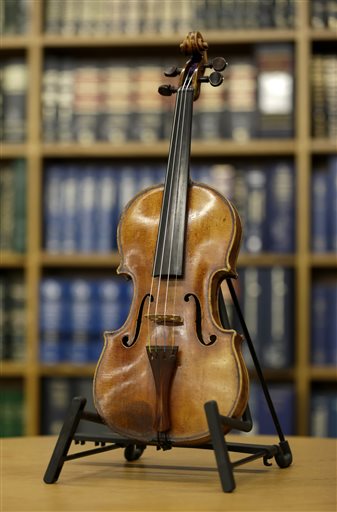 An Ames Stradivarius violin is displayed during a news conference in New York, Thursday, Aug. 6, 2015. The instrument was stolen from renowned violinist Roman Totenberg 35 years ago when he left his beloved Stradivarius in his office while greeting well-wishers after a concert in 1980. According to court documents, a woman voluntarily returned the violin to the Totenberg family and told investigators she did not know it was stolen. (AP Photo/Seth Wenig)