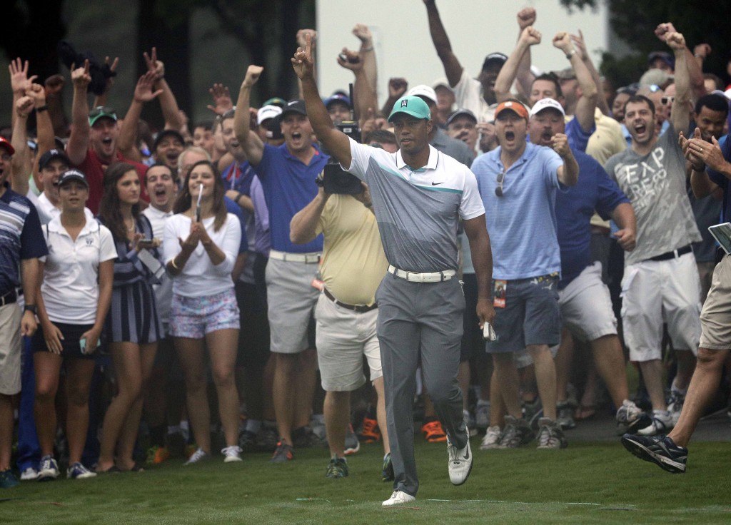 Tiger Woods reacts after holing out a chip shot on the 10th hole during the first round of the Wyndham Championship golf tournament in Greensboro, N.C., Thursday, Aug. 20, 2015. (AP Photo/Chuck Burton)