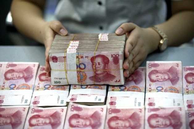 A bank clerk counts renminbi banknotes in a bank branch in Huaibei in central China's Anhui province Wednesday Aug. 26, 2015. Asian stocks rose Wednesday after a rocky start following Beijing's decision to cut a key interest rate to help stabilize gyrating financial markets and free up more funding to counter short liquidity. (Chinatopix Via AP)