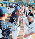 A player from South Korea's Gyeonggi Provincial Police Agency's baseball team high fives another policeman at the LAPD's Wild Wild West Invitational Tuesday. (Park Sang-hyuk/Korea Times)