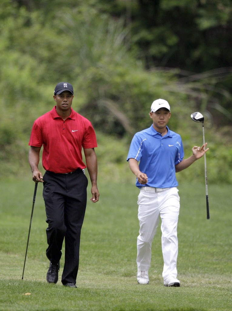 Tiger Woods, left, and Anthony Kim, right, walk down the 11th fairway during the final round of the AT&T National golf tournament at Congressional Country Club, Sunday, July 5, 2009, in Bethesda, Md. (AP Photo/Rob Carr)