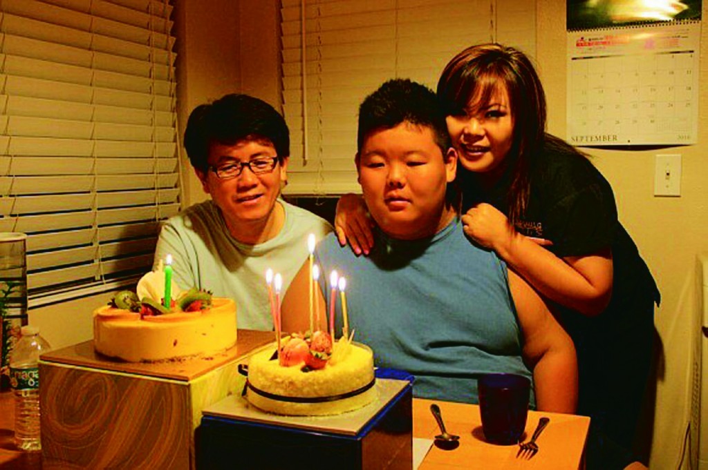 Hun Joon Lee, center, with his parents Lee Sang-sik, left, and Lee Eun-ha, right, celebrating his 15th birthday.