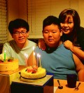 Hun Joon Lee, center, with his parents Lee Sang-sik, left, and Lee Eun-ha, right, celebrating his 15th birthday.