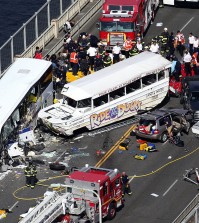 Emergency personnel work at the scene of a fatal collision involving a charter bus, center left, and a "Ride the Ducks" amphibious tour bus on the Aurora Bridge in Seattle on Thursday, Sept. 24, 2015. (Ken Lambert/The Seattle Times via AP)