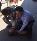 New York State Assemblyman Ron Kim holds down a purse snatcher Thursday in downtown Flushing after tackling the thief.