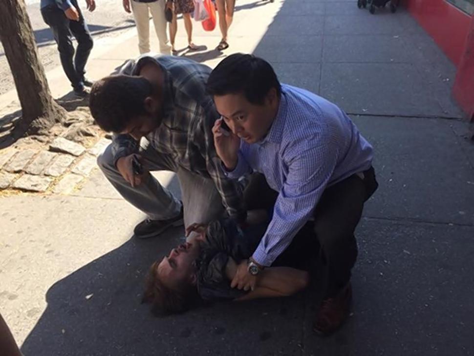 New York State Assemblyman Ron Kim holds down a purse snatcher Thursday in downtown Flushing after tackling the thief.